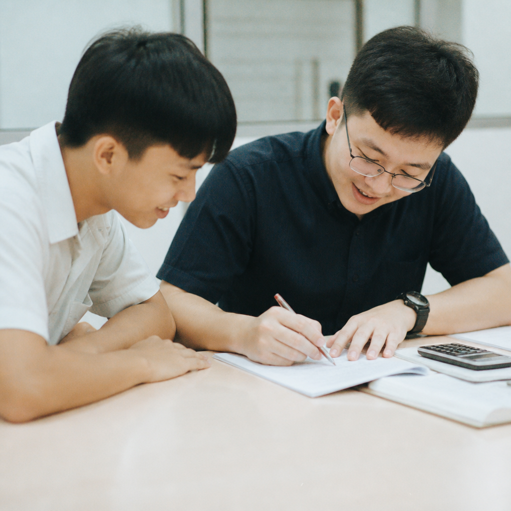 A JC student and tutor reviewing A Levels mistakes together during targeted exam preparation in Singapore.